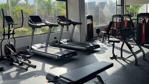 Una palestra con tapis roulant, macchinari per pesi e panche.