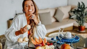 Una mesa de comedor con varios platos y una persona sentada.