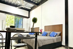 Un dormitorio moderno con cama, escritorio y silla.