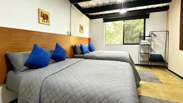Een kamer met twee bedden, een raam en een metalen rek.