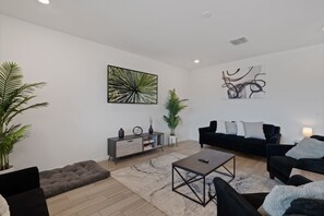 Ein modernes Wohnzimmer mit einer Couch, einem Couchtisch und Zimmerpflanzen.