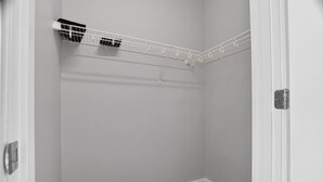 Un coin de pièce avec une porte blanche, un radiateur blanc et un plafond blanc.