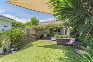 A backyard with a patio, seating area, and a covered section. - West LA Beachy Bungalow (Los Angeles)