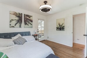 A bedroom with a bed, a ceiling fan, and artwork on the walls. - West LA Beachy Bungalow (Los Angeles)
