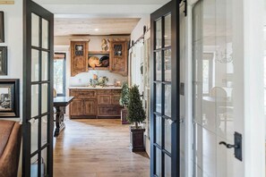 A kitchen with wooden cabinets, a central island, and a potted plant. - Historic Lakefront Farmhouse on Battle Lake - Sleeps 9 (Battle Lake)