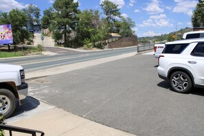 A road with a white SUV parked on the side, a pedestrian crossing, and a billboard in the background.
