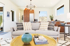 A modern living room with a sofa, coffee table, and a view of the outside. - Shelter 1 by Homestead Modern (Joshua Tree)