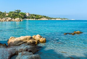 A coastal landscape with clear blue waters, rocky formations, and a building on a hill. - Charming 2-bedroom House in Gallura, North-east Sardinia (Santa Teresa di Gallura)