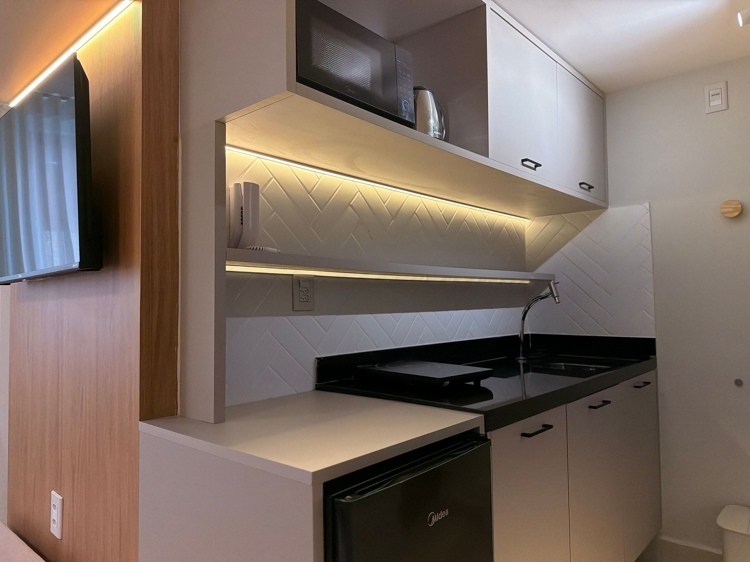 A compact kitchen with a dishwasher, a microwave, and a built-in oven.