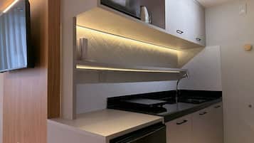 A compact kitchen with a dishwasher, a microwave, and a built-in oven.