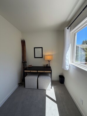 A room with a desk, a lamp, a framed quote on the wall, and a window with a view. - Woodside Retreat Estate - Home + Guest Barn (Bend)