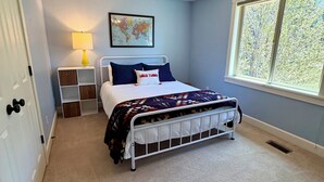 A bedroom with a bed, a ceiling fan, a window, and a wall-mounted lamp. - Woodside Retreat Estate - Home + Guest Barn (Bend)