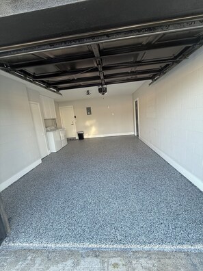 A garage with a concrete floor, white walls, and a black ceiling. - 3-bedroom 2 bath house in serene Tampa 4 min drive from airport (Tampa)