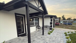 Una casa moderna con un portico coperto, un garage e una strada di accesso privata.