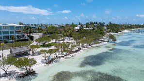 A coastal resort with beachfront properties, clear turquoise waters, and tropical vegetation. - Islamorada Waterfront Retreat Private Beach, Boat Lift & Canal Access (Islamorada)