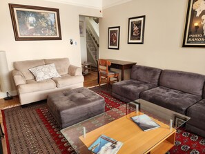 A living room with a beige sofa, a grey sofa, a glass coffee table, and a patterned rug. - Sunny, Spacious 3-bedroom apartment in Vibrant Mission District of San Francisco (San Francisco)