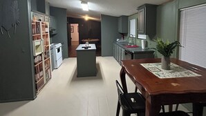 A spacious kitchen with a central island, a dining area with a table and chairs, and a small kitchenette. - Adorable 3-bedroom  home great for fishing on a private lake in Central Georgia (Macon)