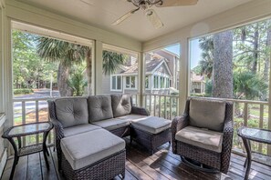 A covered porch with a sectional sofa, two armchairs, and a small table. - Steps to Beach | Palmetto Dunes Pool & Hot Tub (Hilton Head Island)