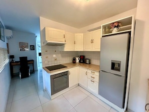 A modern kitchen with white cabinets, a stainless steel refrigerator, a built-in oven, and a coffee maker. - A007 - Appartement chic au coeur de Cannes (Cannes)