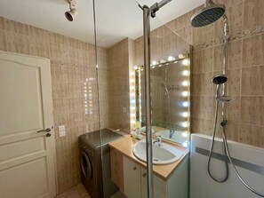 A bathroom with a glass-enclosed shower, a vanity with a mirror, and a bathtub. - A007 - Appartement chic au coeur de Cannes (Cannes)
