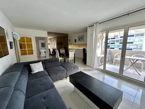 A modern living room with a sectional sofa, a coffee table, and a dining area with chairs and a table. - A007 - Appartement chic au coeur de Cannes (Cannes)