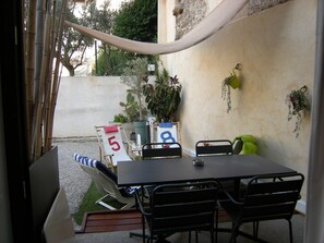 An outdoor seating area with a table and chairs, a number 5 sign, and potted plants. - A088 Élégant duplex avec terrasse, plages, centre (Cannes)