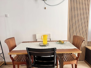 A dining table with four chairs, a yellow mug, and a banana on a placemat. - A088 Élégant duplex avec terrasse, plages, centre (Cannes)