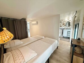 A hotel room with two beds, a lamp, a mirror, and a view of the bathroom and balcony. - A088 Élégant duplex avec terrasse, plages, centre (Cannes)