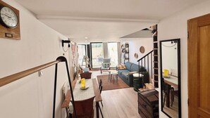 Ein modernes Interieur mit Essbereich, einer Couch und einer Treppe.