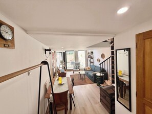 A modern interior with a dining area, a sofa, and a staircase. - A088 Élégant duplex avec terrasse, plages, centre (Cannes)