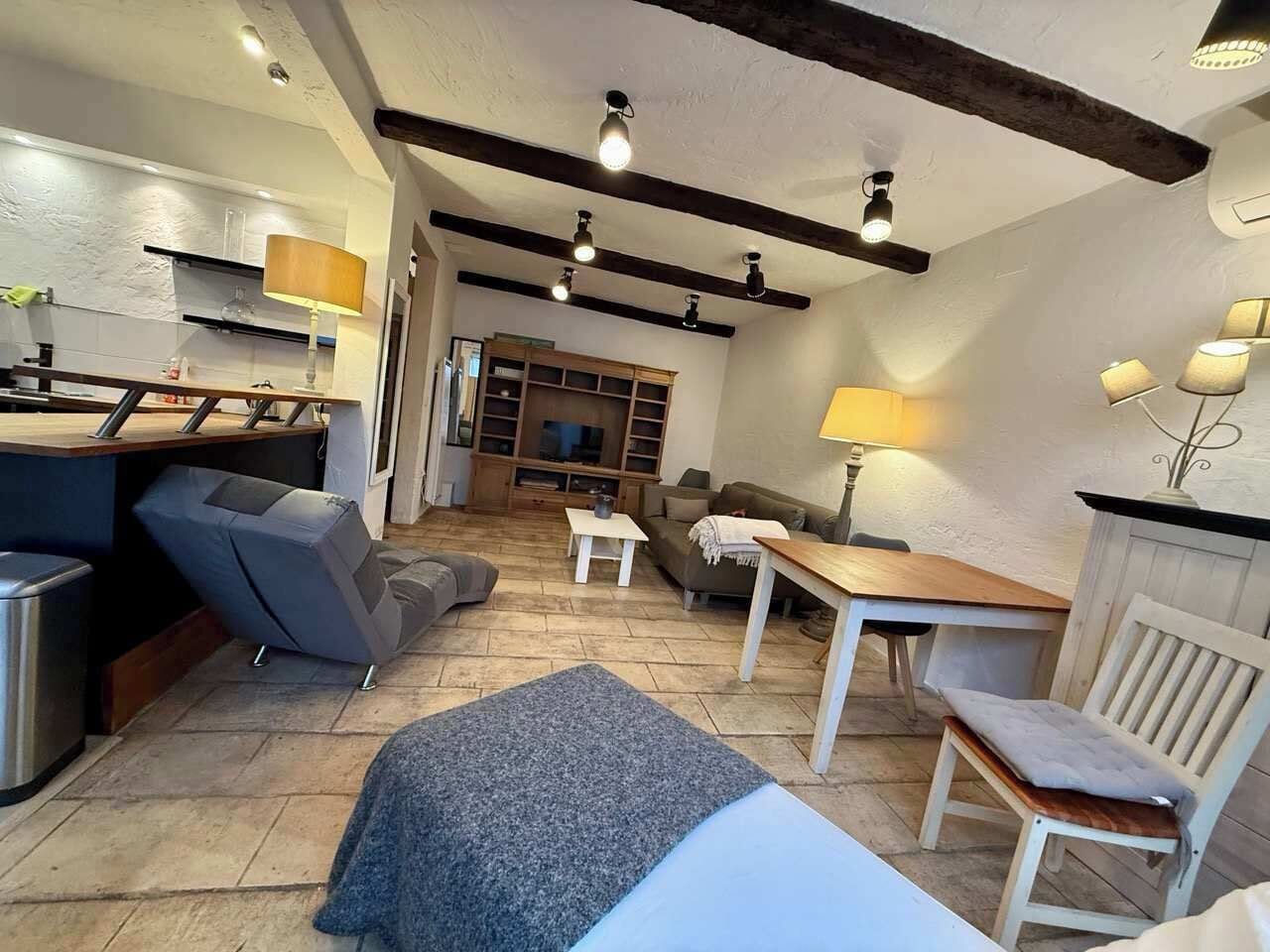 A cozy living area with a sofa, a dining table, and a kitchen area with a counter.