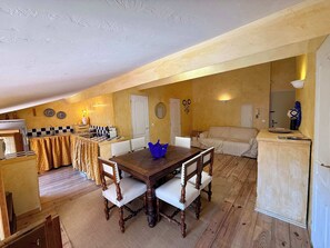 A compact living space with a dining table, chairs, a kitchen area, and a sofa. - A035 Bel appartement atypique Suquet (Cannes)