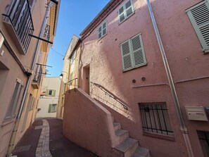A narrow street with a pink building, a staircase, and a metal railing. - B003 Superbe 2 chambres centre Cannes (Cannes)