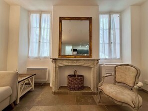 A room with a fireplace, a mirror, a chair, and a table. - B003 Superbe 2 chambres centre Cannes (Cannes)
