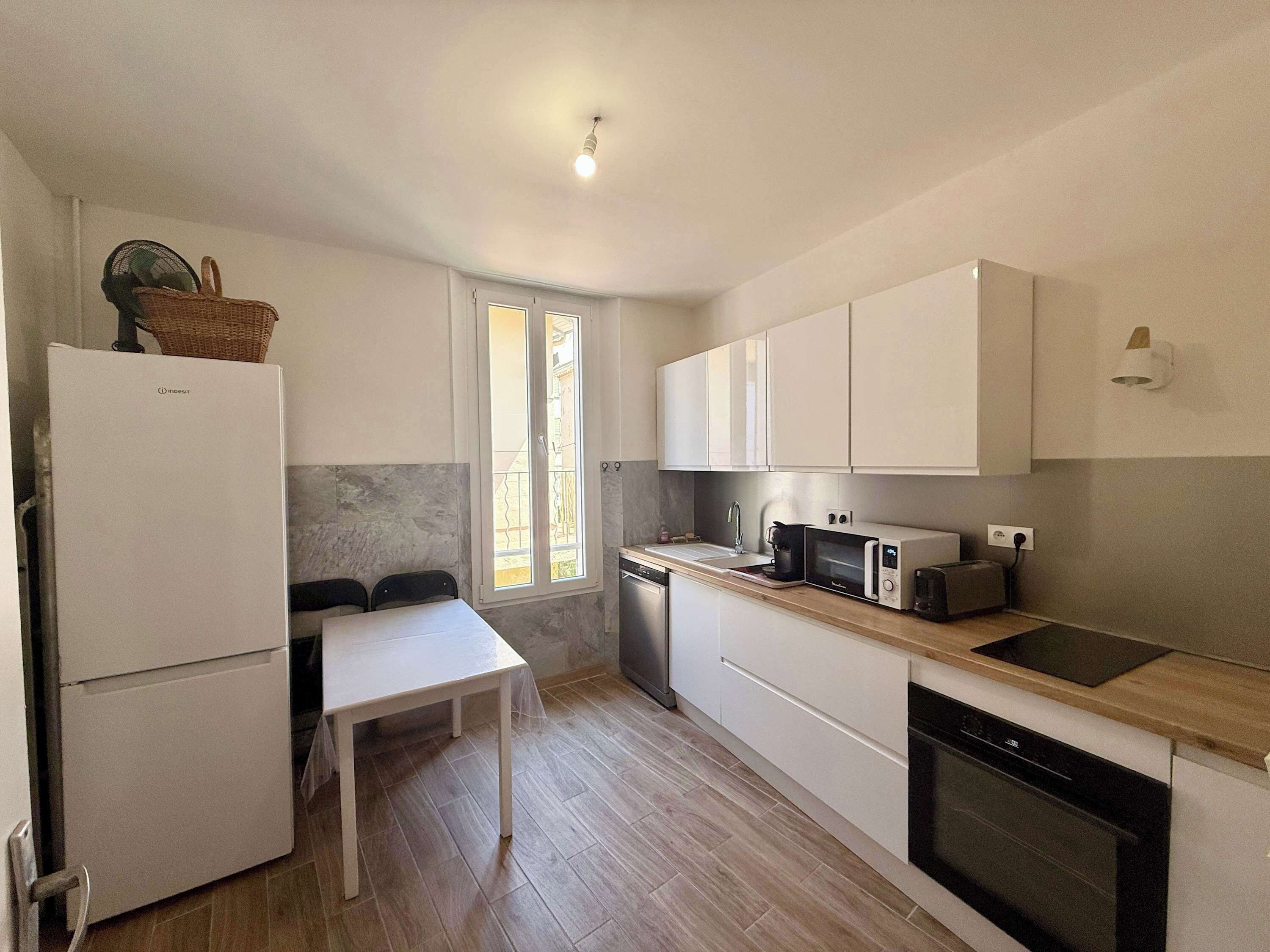 A compact kitchen with a refrigerator, microwave, toaster, and a sink.