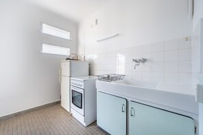 A compact kitchen with a refrigerator, oven, sink, and cabinets. - A056 - Nice Studio Cannes centre with parking (Cannes)