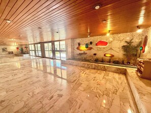 A spacious lobby with a polished marble floor, wooden ceiling, and a reception desk with a plant and wall-mounted lights. - B027 Magnifique 3 chambres parking, tout à pied (Cannes)