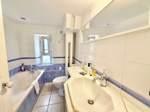 Ein Badezimmer mit Badewanne, Toilette und Waschbecken.