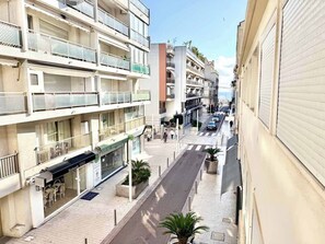 A multi-story building with balconies, a street in the foreground, and a clear sky. - B044 Studio moderne Croisette 100m (Cannes)