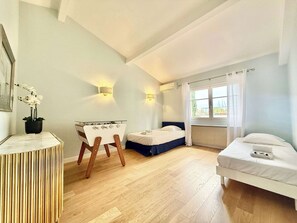 A bedroom with a bed, a desk, and a chair. There is a window with curtains and a view of the outside. - B077 Superbe villa avec piscine centre de Cannes (Cannes)