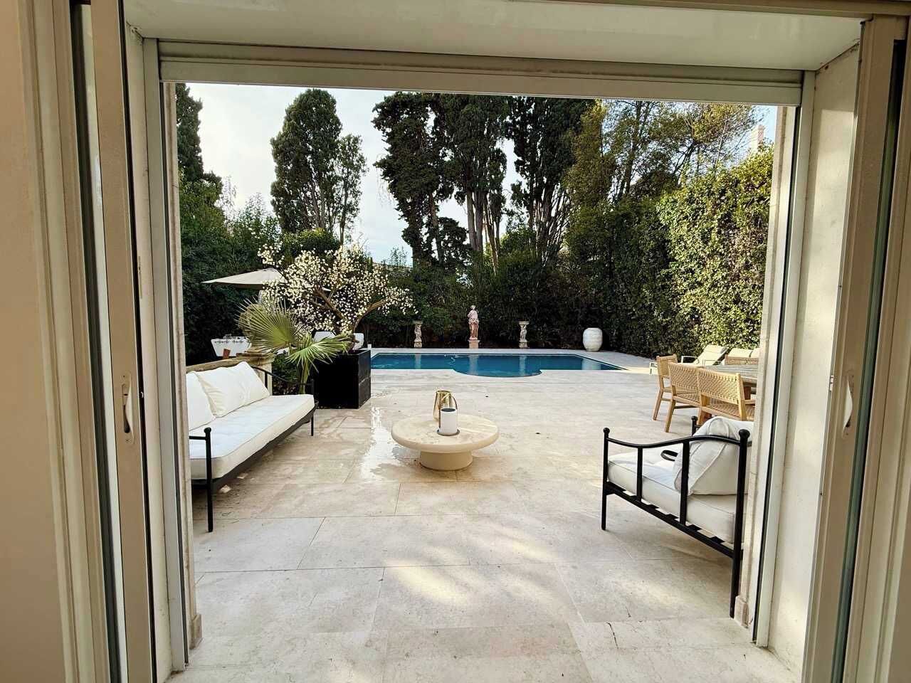 Eine Außenpatio mit Pool, Sitzbereich und einem runden Tisch.