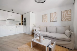 Uma sala de estar moderna com um sofá, uma mesa de centro e uma estante.