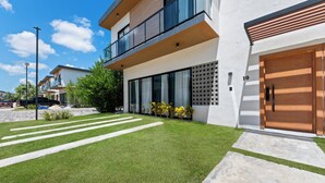 En moderne toetages boligbygning med en velplejet græsplæne, indkørsel og garage.