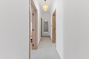 Ein Korridor mit Holztüren, einem Spiegel und einer Hängelampe.