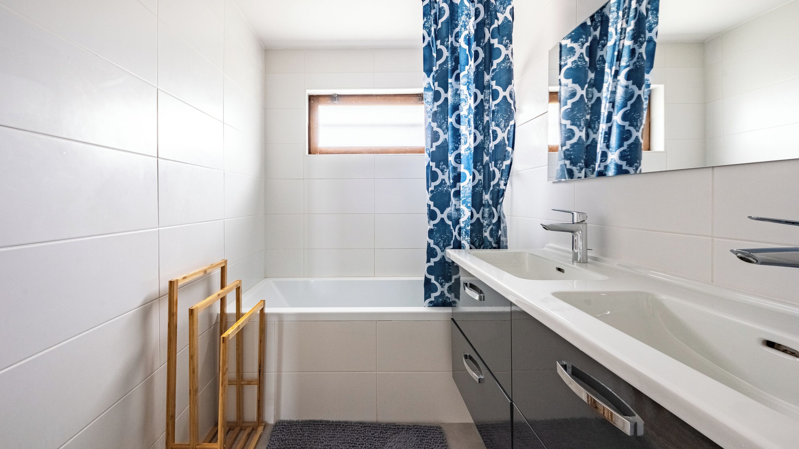 Un baño moderno con bañera, lavamanos y ventana.