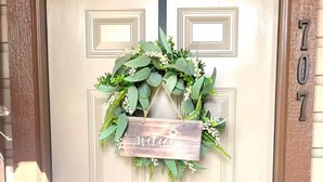 A beige door with a welcome sign and a number '707' above it. - Cozy 1-bedroom condo near Lake Conroe (Montgomery)