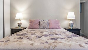 Ein Schlafzimmer mit einem Bett, zwei Nachttischen und zwei Lampen.