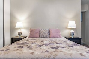 Ein Schlafzimmer mit einem Bett, zwei Nachttischen und zwei Lampen.