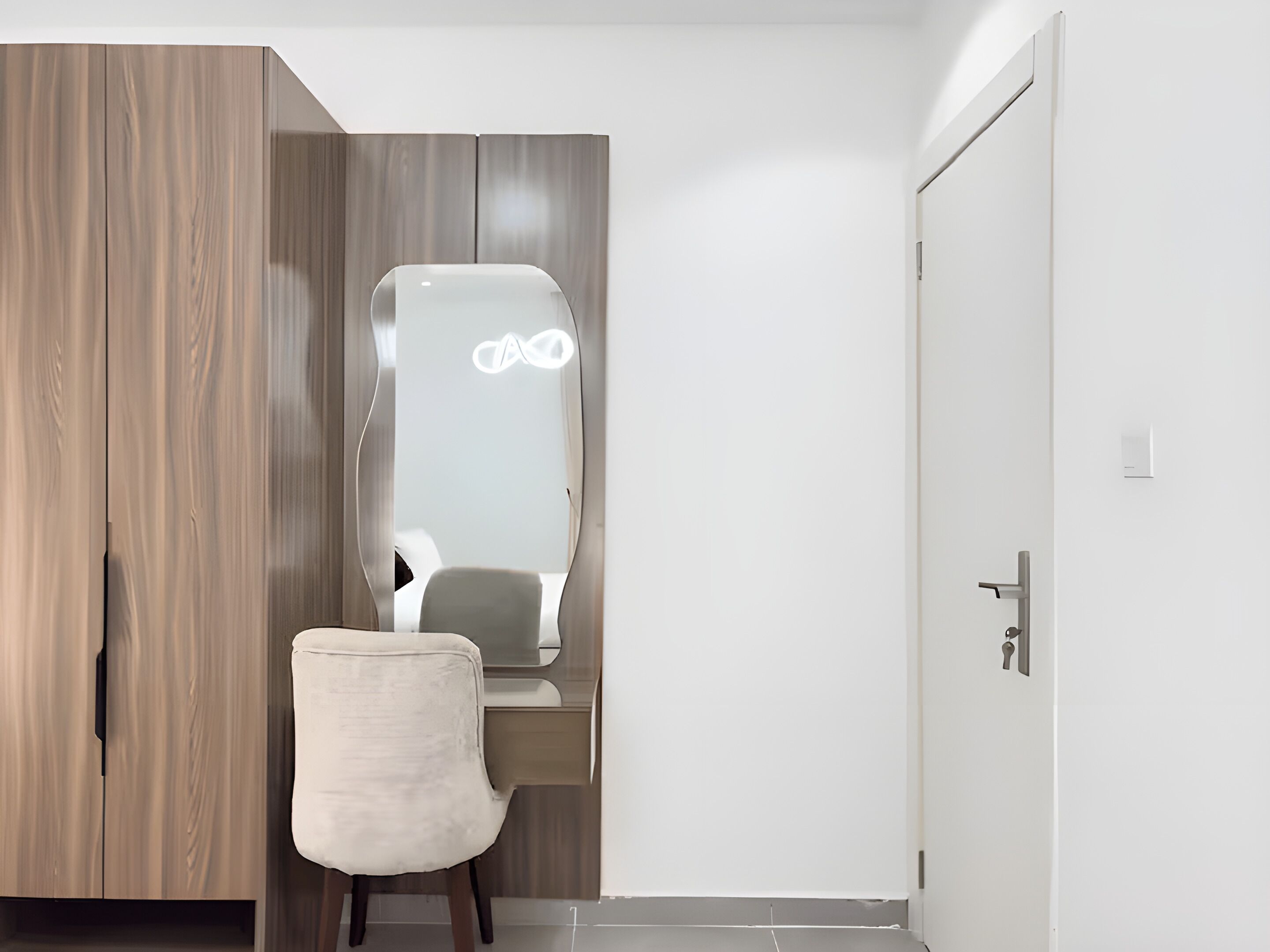 A room with a vanity, a chair, and a wardrobe.