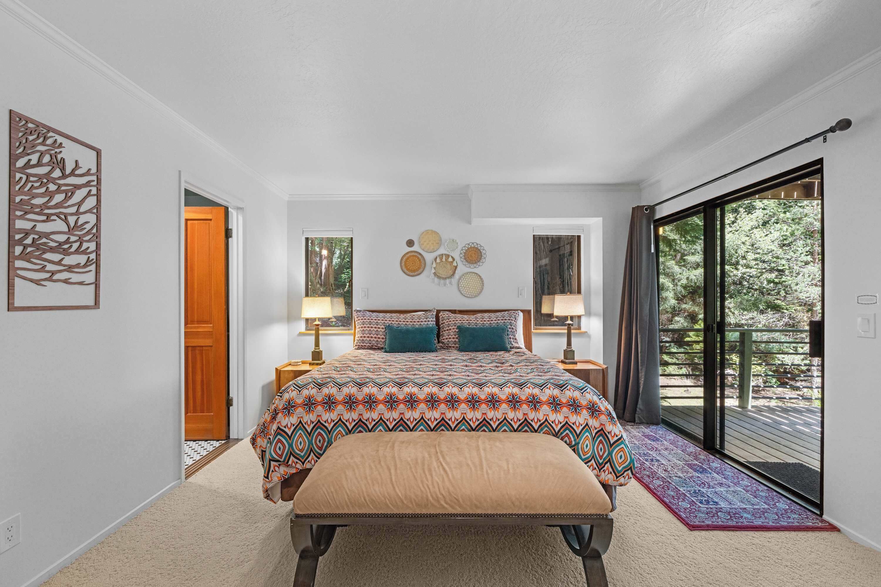 From the primary bedroom, step through the slider onto the deck or through the open door into the ensuite spa bath.
